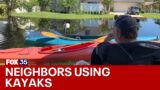 Florida residents commute to homes by canoe through flooded neighborhoods