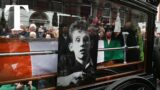 Crowds sing Fairytale of New York during Shane MacGowan's funeral procession